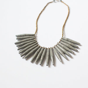 JustOne's necklace with long grey paper beads dangling off, handcrafted in Uganda