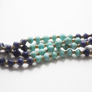 JustOne's paper bead necklace in teal and navy, handcrafted in Uganda