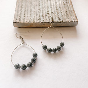 JustOne's silver hoop earrings with five grey paper beads on the bottom of the hoop, handcrafted in Uganda